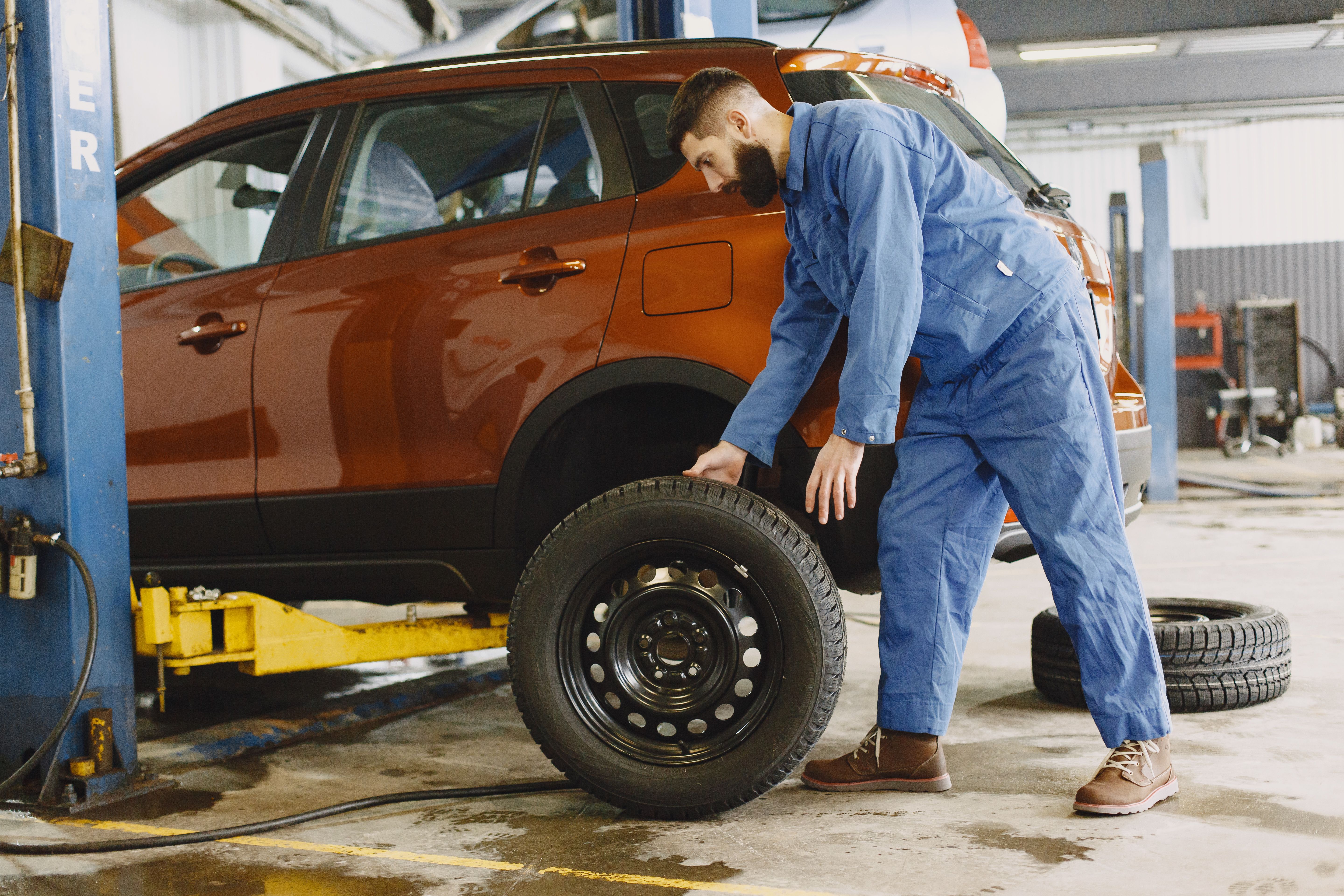 Professional tire technician mounting a tire on a wheel in a modern service center